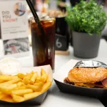 A mouth-watering burger paired with golden, crispy chips and a chilled glass of Coke.